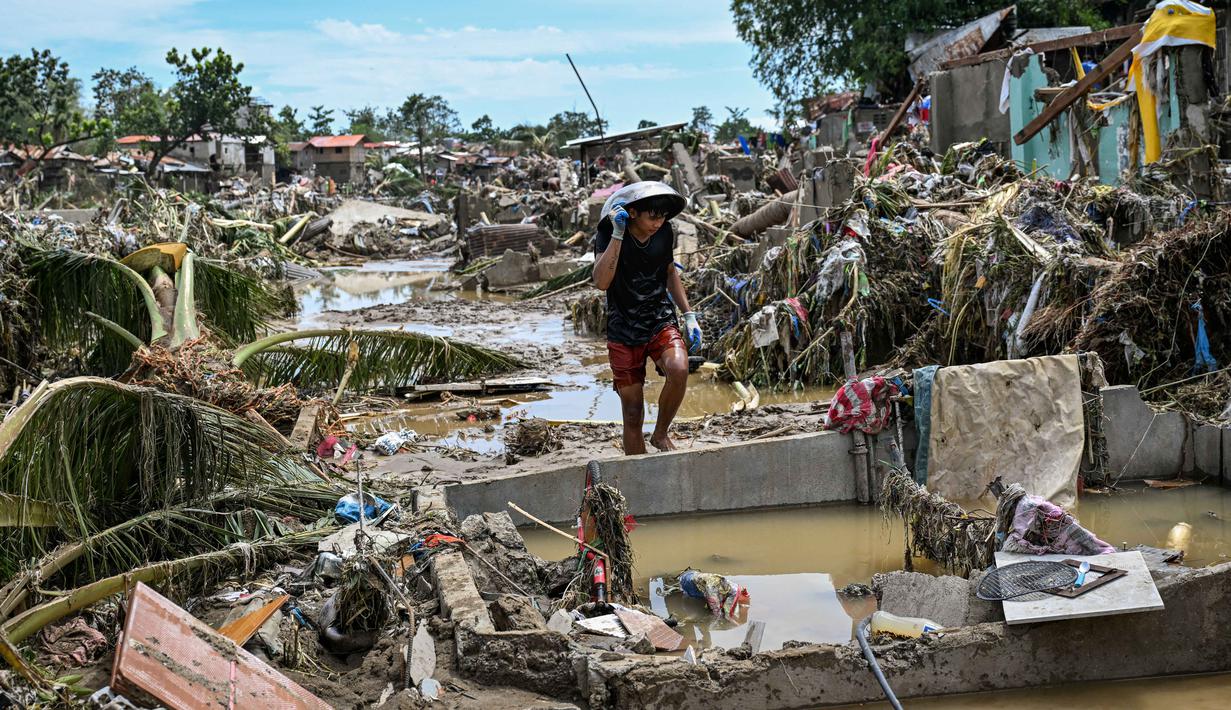 Seorang warga berjalan di antara rumah-rumah yang rusak akibat terjangan Topan Kalmaegi di Talisay, Provinsi Cebu, Filipina pada Rabu 5 November 2025. Cebu, rumah bagi lebih dari 2,4 juta penduduk, kini berada dalam status bencana. (Jam STA ROSA/AFP)