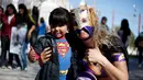 Pegulat Jerman 'Diosa del Rhin' (Dewi Rhin) berpose dengan seorang bocah saat aksi kesetaraan gender di Ciudad Juarez, Meksiko (13/3/2016). Selain pegulat, Rhin juga merupakan seorang aktivis perempuan. (Reuters/Jose Luis Gonzalez)