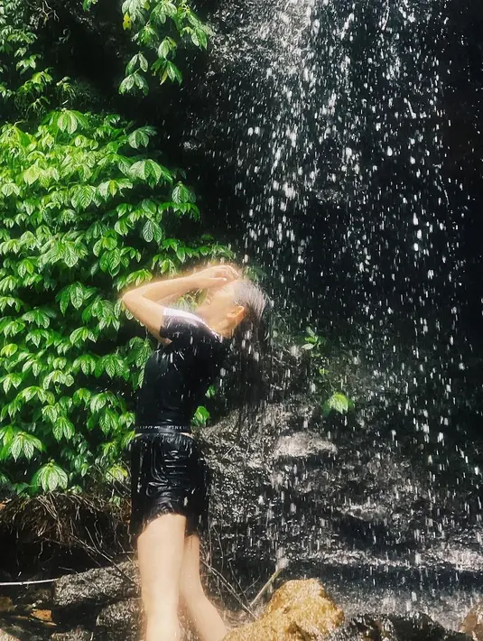 Tak hanya cukup memandangi keindahannya, Natalie Zenn menikmati aliran air terjun yang menghujaninya. Momen ini sukses jadi healing pemeran sinetron "Dewi Rindu" ini. (Liputan6.com/IG/@nataliezenn24).