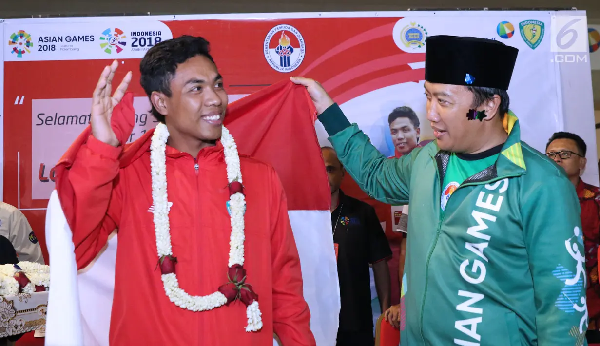 Menpora, Imam Nahrawi (kiri) melihat medali emas yang diraih Lalu Muhammad Zohri pada Kejuaraan Dunia Atletik U-20 di Finlandia saat penyambutan di Terminal 3 Bandara Soetta, Tangerang, Selasa (17/7). (Liputan6.com/Helmi Fithriansyah)