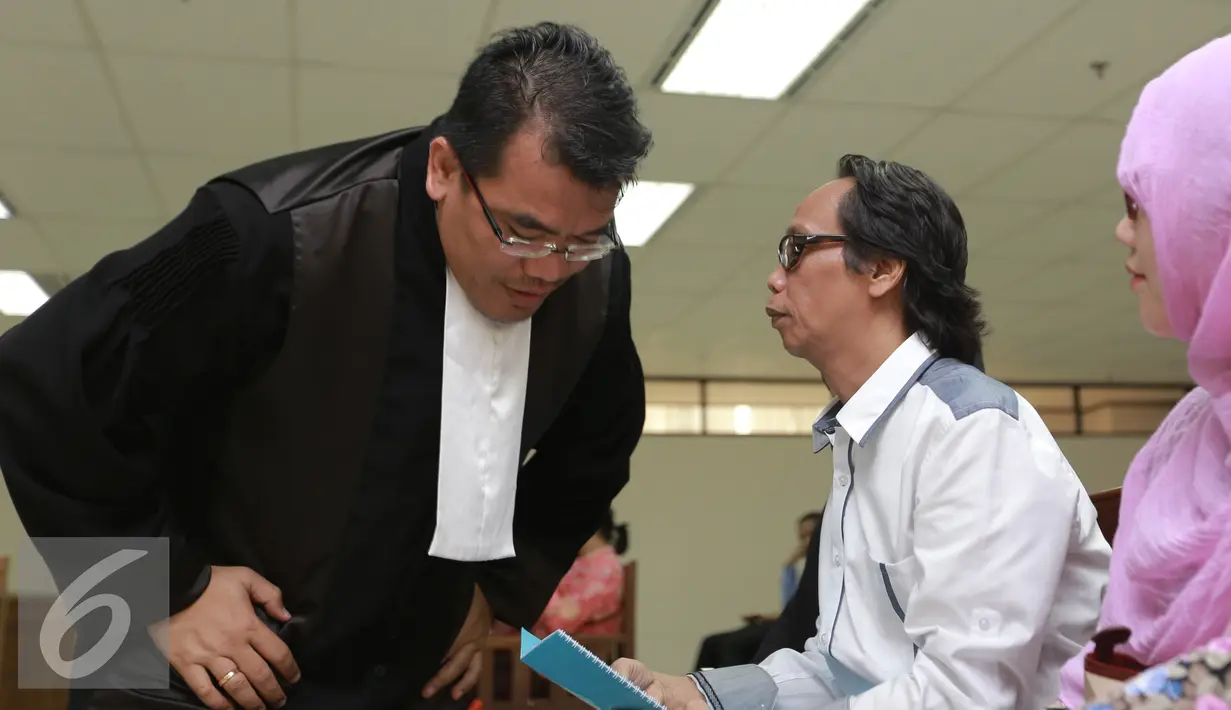 Mandra Naih (kanan) saat berbincang dengan kuasa hukumnya sebelum  menjalani sidang lanjutan di Pengadilan Tipikor, Jakarta, Senin (31/8/2015). Sidang ini beragendakan pembacaan eksepsi atau nota keberatan dari terdakwa. (Liputan6.com/Herman Zakharia)