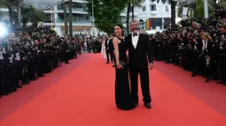 Aktor senior Mel Gibson didampingi pacar barunya, Rosalind Ross tiba untuk menghadiri acara penutupan Festival Film Cannes ke-69 di Prancis, 22 Mei 2016. Keduanya tampak kompak berdandan klasik dan elegan dengan tuxedo dan gaun hitamnya (AFP PHOTO)