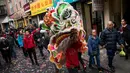 Seorang peserta memainkan Barongsai saat menyusuri Chinatown selama festival budaya perayaan Imlek di New York City (16/2). Warga Tionghoa bersama berbaur dengan masyarakat sekitar turun ke jalan memadati kawasan Chinatown. (Drew Angerer/Getty Images/AFP)