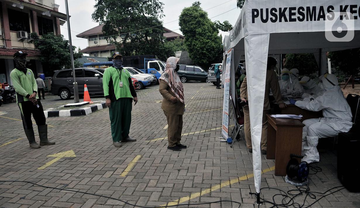 Peseta antre saat akan melakukan tes swab COVID-19 di Kantor Kecamatan Kramat Jati, Jakarta, Selasa (16/6/2020). Puskesmas Kecamatan Kramat Jati menggelar tes swab bagi seluruh pegawai instansi pemerintahan untuk memutus rantai penyebaran COVID-19. (merdeka.com/Iqbal Nugroho)