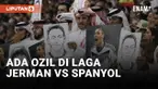 Aksi balasan pada timnas Jerman yang menutup mulut di laga perdana sebagai protes terhadap FIFA dan tuan rumah Qatar diperlihatkan suporter Qatar. Di laga Jerman kontra Spanyol pendukung Qatar membawa poster mantan pemain timnas Jerman Mesut Ozil yan...