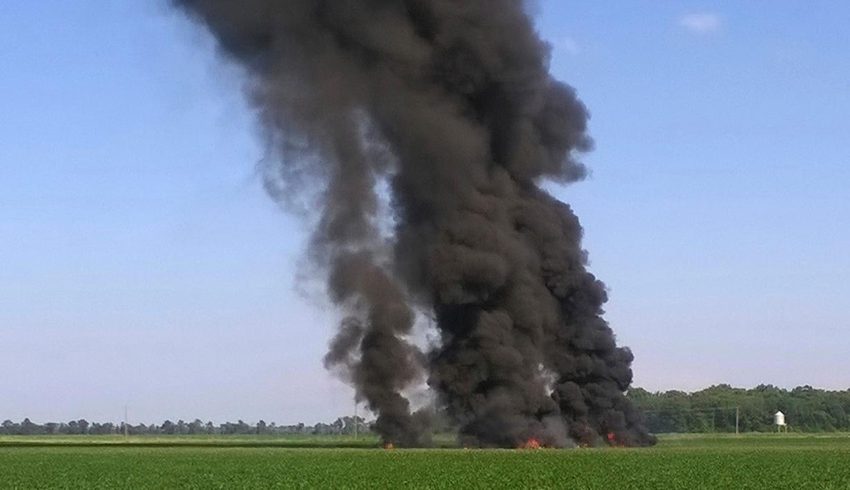 Kepulan asap hitam mengudara setelah sebuah pesawat milik korps marinir AS jatuh di jalur county Sunflower-Leflore, negara bagian Mississippi, Senin (10/7). Pesawat Hercules KC-130 itu difungsikan sebagai pengisi bahan bakar di udara. (Jimmy Taylor via AP