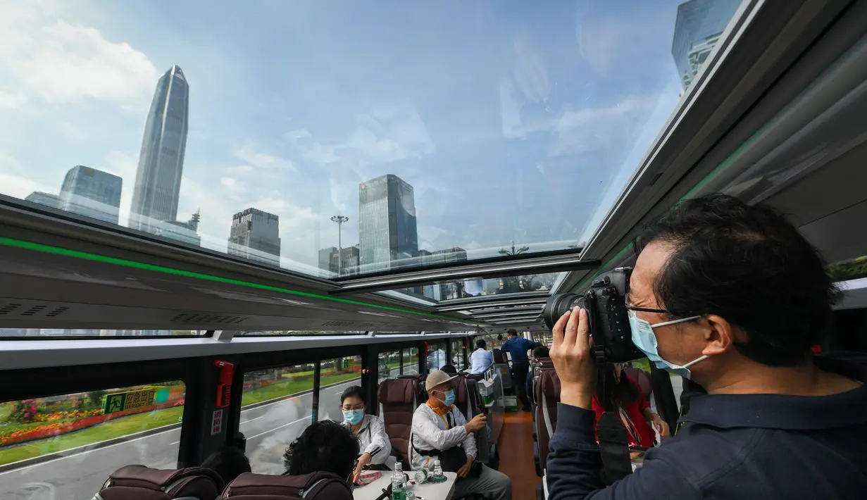 Seorang jurnalis mengambil foto di dalam sebuah bus wisata di Shenzhen, Provinsi Guangdong, China (22/10/2020). Shenzhen pada Kamis (22/10) meluncurkan tiga jalur bus wisata bagi wisatawan, yang masing-masing menampilkan budaya, teknologi, dan pemandangan malam kota tersebut. (Xinhua/Mao Siqian)