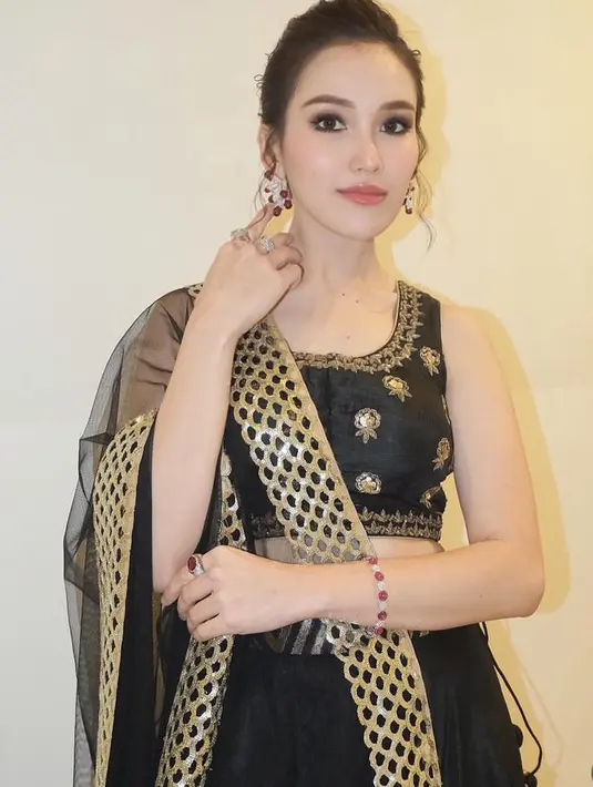 Wajahnya pun dirias flawless dengan blush on pink tipis dan lipstik glossy nude. Dengan riasan mata smokey mengenakan eye shadow hitam menyesuaikan warna busananya. [@ayutingting92]