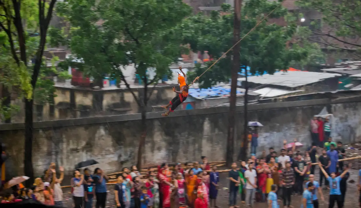Seorang penganut Hindu tergantung dengan kaitan yang ditusuk di punggungnya saat festival Charak Puja di Dhaka, Bangladesh (14/4). Mereka juga percaya festival ini dapat menghilangkan kesedihan dan penderitaan tahun sebelumnya. (AP Photo / A.M. Ahad)