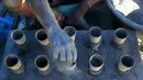 Seorang pekerja menambahkan bubuk mesiu ke dalam silinder karton untuk membuat kembang api di dalam pondok di kota Bocaue, provinsi Bulacan, Filipina, (26/12/2015) Desember 2015. (REUTERS/Romeo Ranoco)