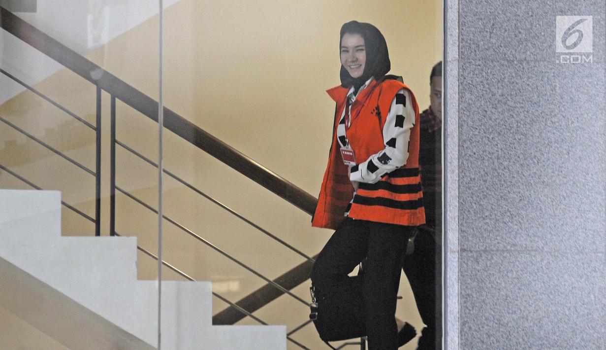 Bupati nonaktif Kutai Kartanegara Rita Widyasari menaiki tangga untuk menjalani pemeriksaan di gedung KPK, Jakarta, Selasa (30/1). Rita tampak berbusana fashionable dengan tangan kanannya yang menjinjing tas perempuan hitam. (Liputan6.com/Herman Zakharia)