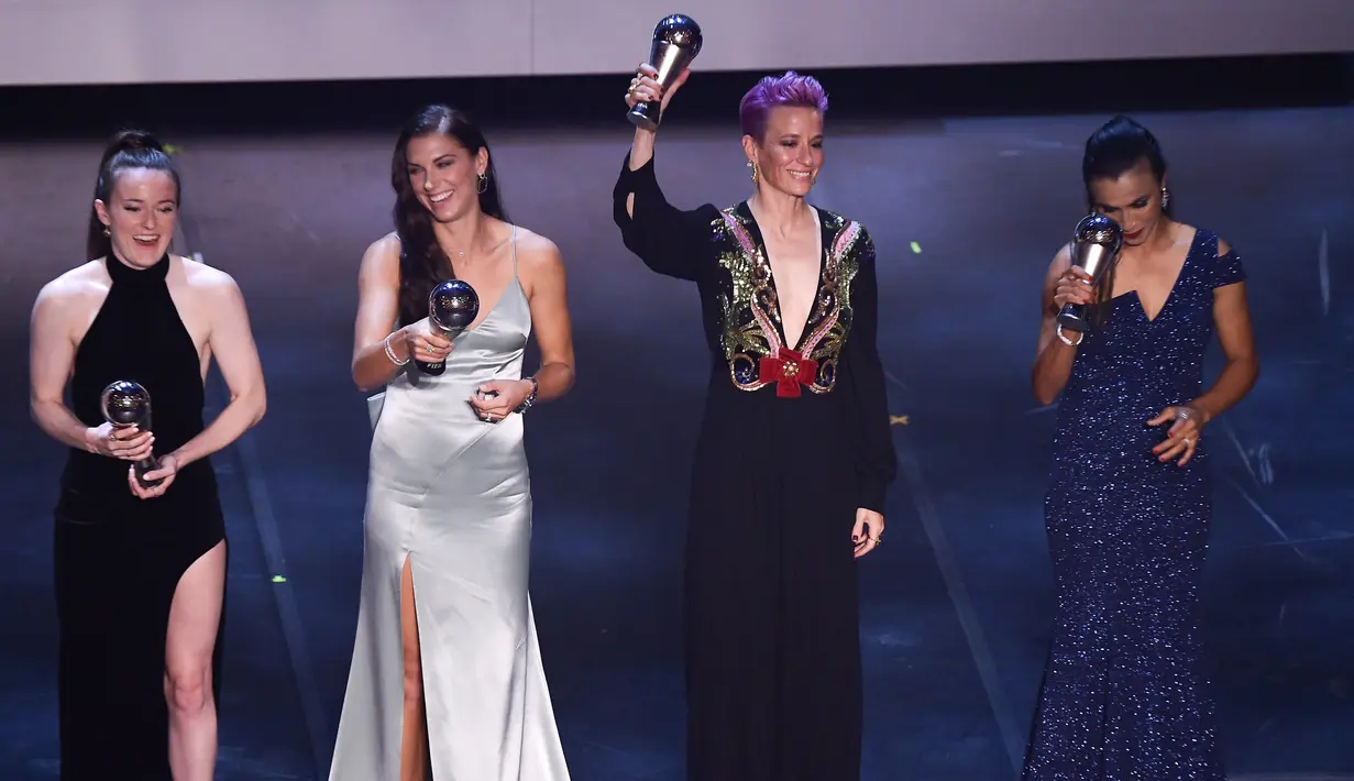 Penyerang Amerika Serikat, Megan Rapinoe (kedua kanan) mengangkat trofi pemain Wanita FIFA Terbaik 2019 saat berpose bersama Rose Lavelle, Alex Morgan dan Marta teater La Scala Milan, Italia utara (23/9/2019). (AFP Photo/Marco Bertorello)