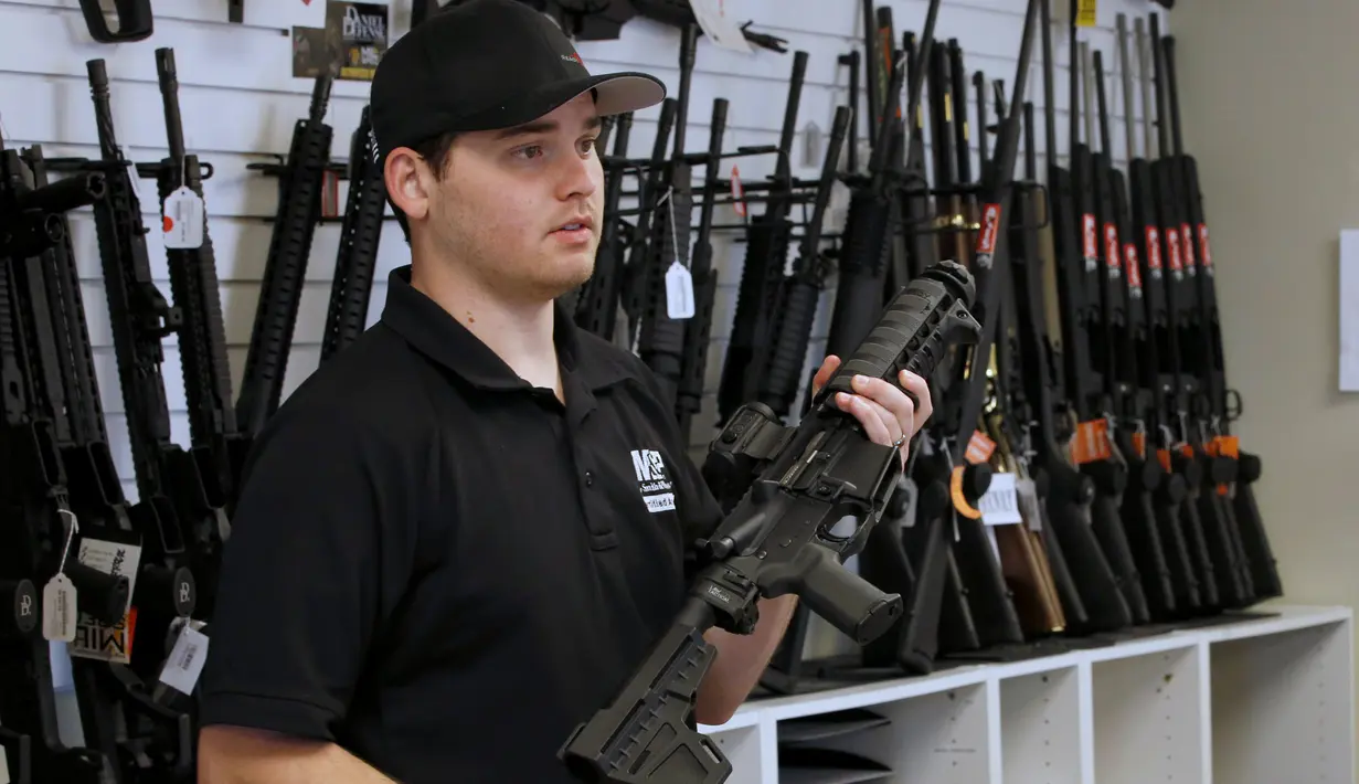 Penjaga toko senjata, Ryan Martinez  memegang senapan serbu AR-15 di toko senjata "Ready Gunner", Utah, AS, (21/6). Maraknya kasus penembakan seperti di Orlando baru terjadi, pemerintah AS akan menerapkan pengendalian senjata api. (REUTERS/George Frey)