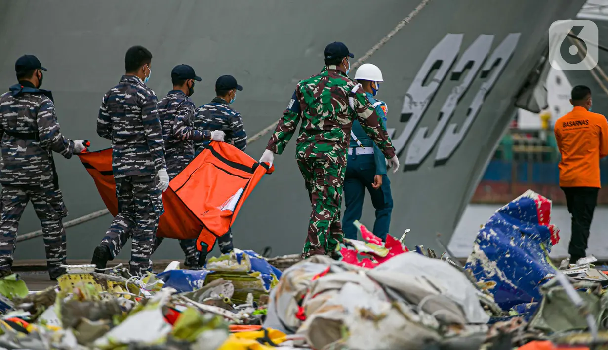 Petugas membawa kantong jenazah di JICT II Tanjung Priok, Jakarta, Senin (18/1/2021). Kepala Basarnas Marsyda (Purn) Bagus Puruhitno menyatakan, operasi SAR gabungan pencarian dan pengevakuasian Sriwijaya Air SJ 182 diperpanjang tiga hari. (Liputan6.com/Faizal Fanani)
