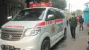 Warga melintas di dekat mobil ambulans di RW 03, Kelurahan Gandasari, Kecamatan Jatiuwung, Kota Tangerang, Rabu (9/6/2021). Pemerintah setempat menerapkan lockdown skala mikro setelah 57 warga di kawasan tersebut terkonfirmasi positif COVID-19. (Liputan6.com/Angga Yuniar)