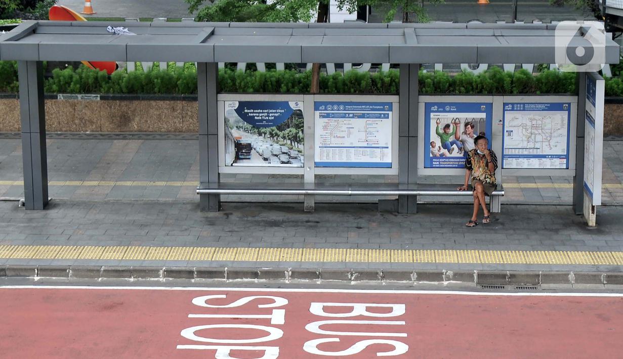 <p> Warga berada di halte bus di Jalan Jenderal Sudirman, Jakarta, Senin (2/5/2022). Hiruk-pikuk kemacetan lalu-lintas di Ibu Kota berubah lengang saat sebagian besar warga mudik ke kampung halaman untuk merayakan Idul Fitri 1443 Hijriah. (merdeka.com/Iqbal S. Nugroho)</p>