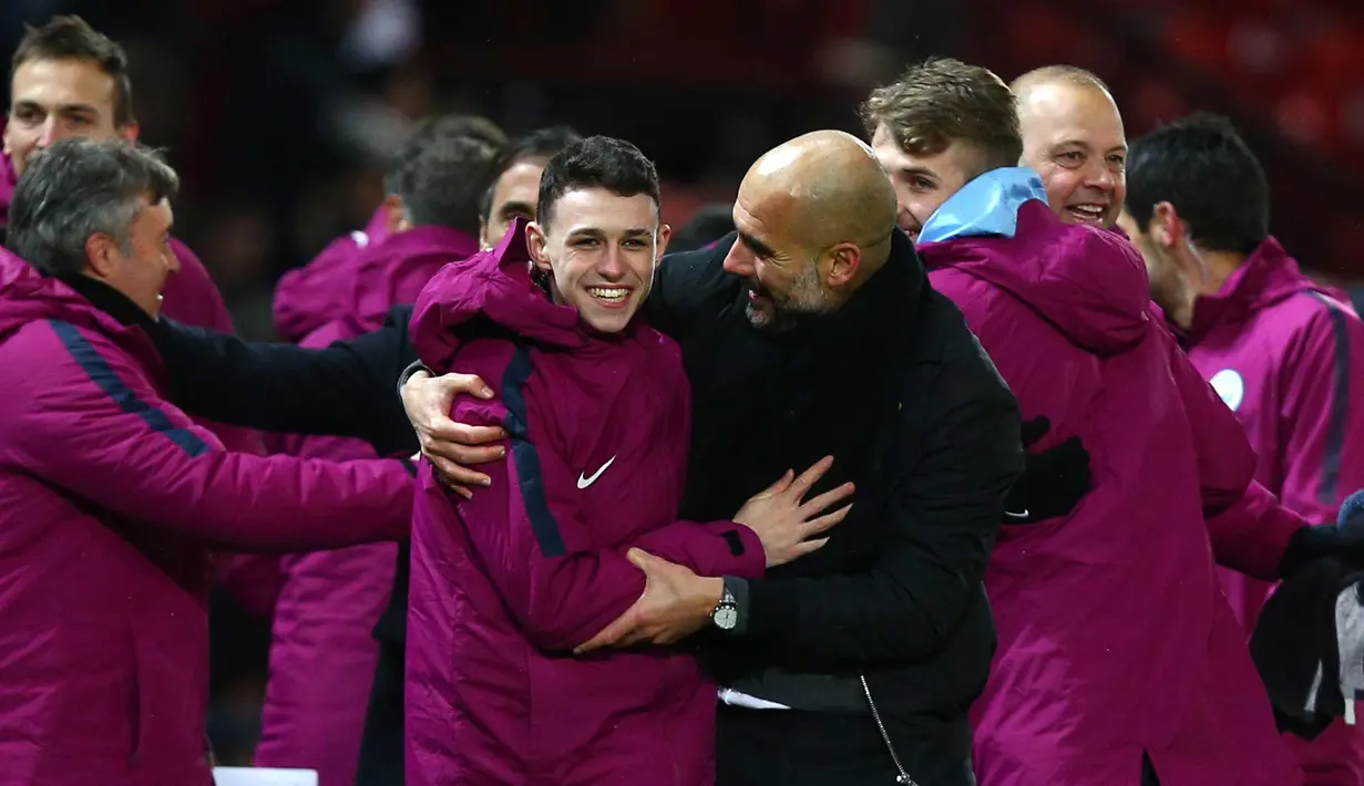 Pep Guardiola (tengah) melakukan selebrasi dengan pemainnya usai pertandingan melawan Manchester United di Liga Inggris di Old Trafford Stadium, Inggris, (10/12). Usai mengalahkan MU, City kokoh di puncak klasemen dengan poin 46. (AP Photo/Dave Thompson)