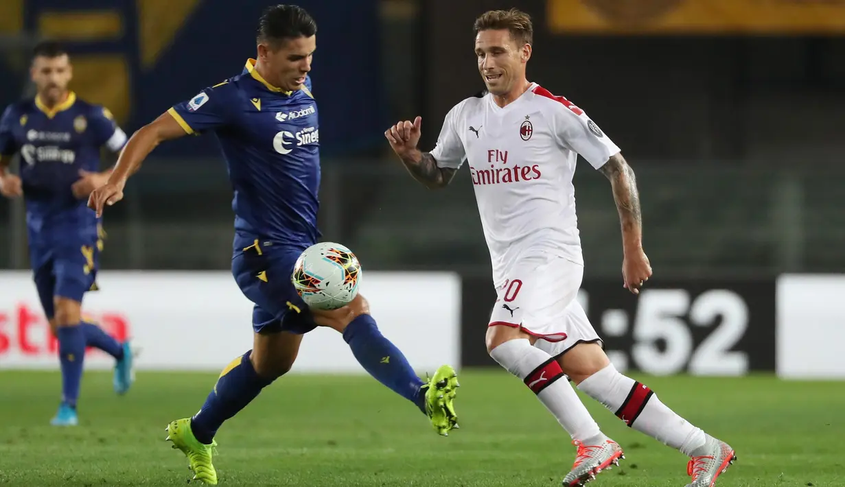 Gelandang AC Milan, Lucas Biglia berebut bola dengan pemain Hellas Verona, Mariusz Stepinski pada pertandingan pekan ketiga Liga Italia di Stadio Marc'Antonio Bentegodi (15/9/2019). AC Milan menang tipis atas Hellas Verona 1-0. (Simone Venezia/ANSA via AP)