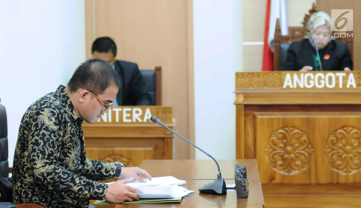 Asisten bantuan hukum LBH Jakarta, Abraham Nempung (kiri) memeriksa berkas saat sidang perdana sengketa informasi publik terhadap Kementerian LHK di Gedung KIP, Jakarta, Kamis (1/3). Sidang beragendakan pemeriksaan awal. (Liputan6.com/Helmi Fithriansyah)