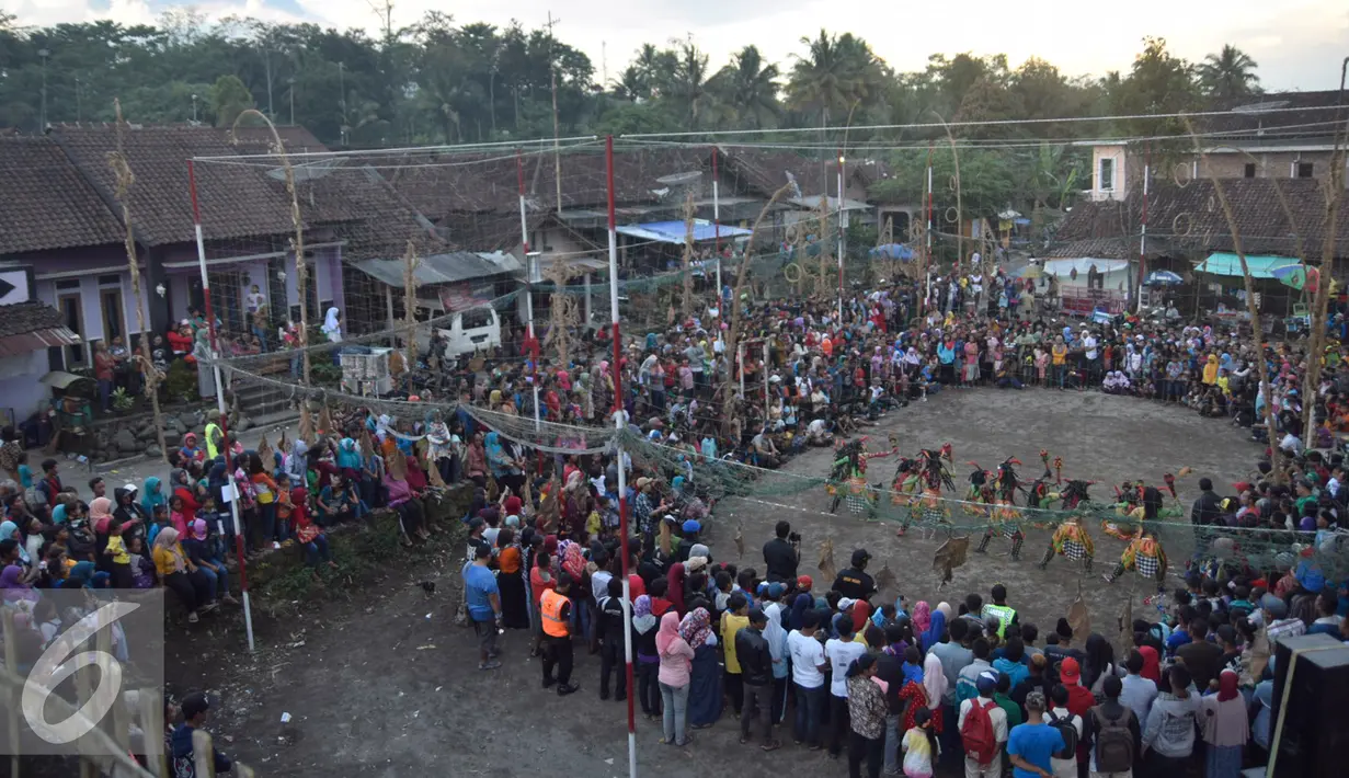 Warga menyaksikan tarian saat Festival Lima Gunung di lereng Gunung Merapi, Desa Klogowanan, Magelang, (21/7). Festival tersebut diselenggarakan secara mandiri oleh petani setiap tahun. (Liputan6.com/Gholib)
