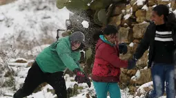 Keceriaan sejumlah anak pengungsi Suriah saat bermain salju di Aley, Lebanon, Jumat (1/12/2016). Badai salju di Lebanon menambah kesengsaraan puluhan ribu pengungsi Suriah yang tinggal di tempat penampungan sementara wilayah tersebut (REUTERS/Jamal Saidi)