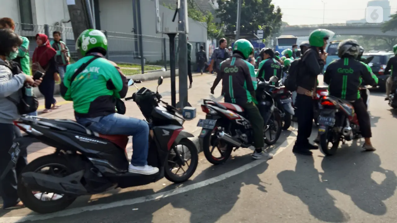 Driver ojek online (ojol) mengambil penumpang di dekat Stasiun Tanah Abang, Jakarta Pusat.