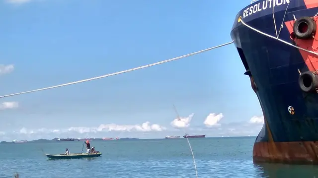 Nelayan dengan perahu mungil berhadapan dengan 'raksasa-raksasa lautan' di Batam. (Foto: Liputan6.com/Ajang Nurdin)