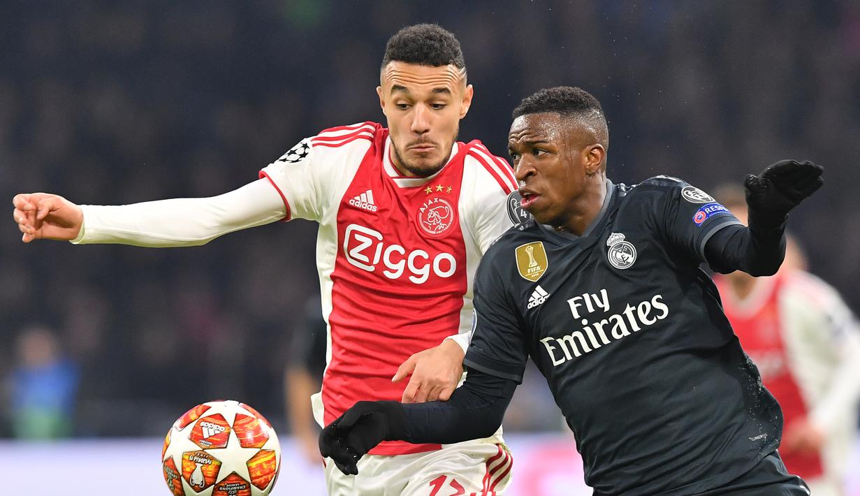 Duel antara Vinicius Jr dan Mazraoiu pada leg 1, 16 besar Liga Champions yang berlangsung di stadion Amsterdam Arena, Amsterdam, Kamis (14/2). Real Madrid menang 2-1 atas Ajax. (AFP/Emmanuel Dunand)