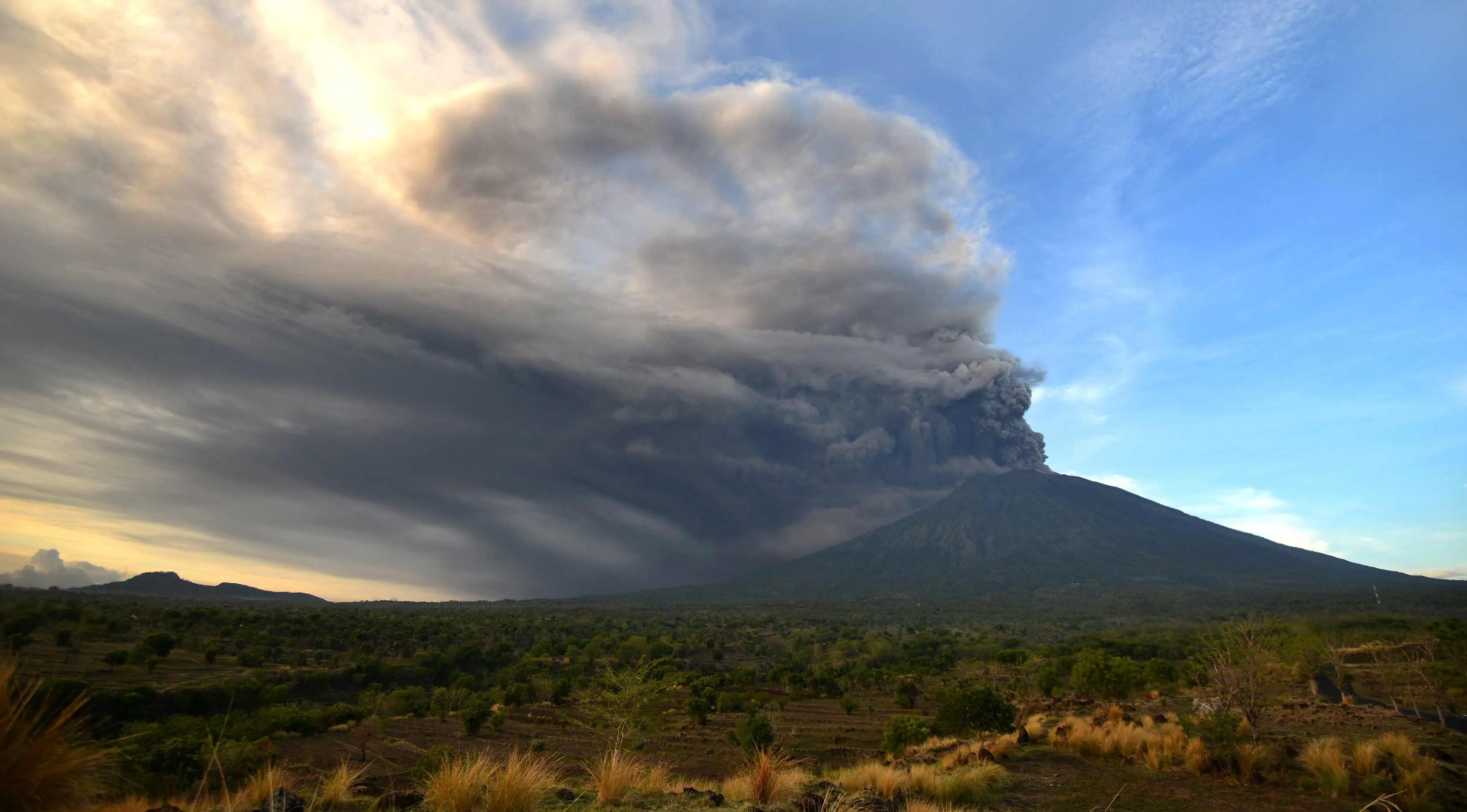 Pemandangan Gunung Agung yang mengeluarkan abu vulkanik di Kecamatan Kubu, Karangasem, Bali, Minggu (26/11). Semburan asap dan abu vulkanik Gunung Agung mencapai ketinggian 1.500 meter dari puncak Gunung Agung. (AFP/Sonny Tumbelaka)