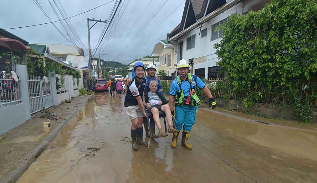 Tim penyelamat mengevakuasi seorang warga dari rumahnya yang terendam banjir menyusul hujan deras yang dibawa oleh Topan Kalmaegi di sebuah permukiman di Kota Cebu, Filipina tengah, pada Selasa 4 November 2025. Dengan hembusan angin berkecepatan hingga 150 kilometer per jam dan hembusan mencapai 205 kilometer per jam, Topan Kalmaegi meninggalkan jejak kehancuran di Kota Cebu, Filipina tengah. (Alan TANGCAWAN/AFP)