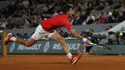 Petenis Serbia, Novak Djokovic berusaha mengembalikan bola pukulan Rafael Nadal dari Spanyol dalam pertandingan perempat final turnamen French Open 2022 di stadion Roland Garros di Paris, Rabu (1/6/2022). Nadal berhasil melaju ke semifinal usai mengalahkan Djokovic dengan skor 6-2, 4-6, 6-2, 7-6(4). (AP Photo/Jean-Francois Badias)