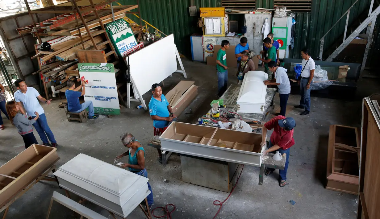 Para mantan pengguna narkoba membuat peti mati di kota Olongapo, Filipina utara, (5/10). Kegiatan ini merupakan bagian dari program rehabilitasi pemerintah setempat bagi mereka yang terjerumus dalam penyalahgunaan narkoba. (REUTERS/Erik De Castro)