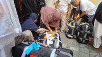 Jemaah haji dari Embarkasi PDG 2 menimbang koper, Kamis (14/7/2022) (Liputan6.com/ Mevi Linawati)
