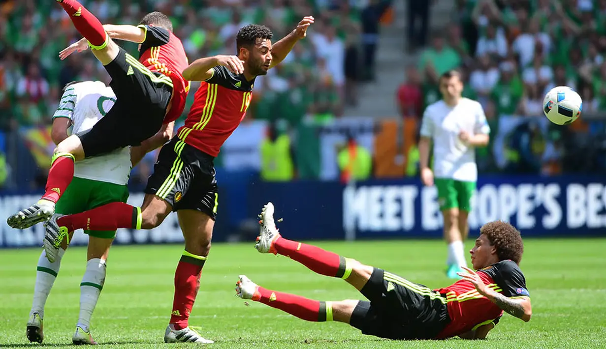 Gelandang Belgia, Moussa Dembele, berebut bola dengan penyerang Irlandia, Shane Long, pada laga Grup E Piala Eropa 2016. Hasil ini membuat Belgia berada pada posisi dua klasemen sementara di bawah Italia. (AFP/Emmanuel Dunand)