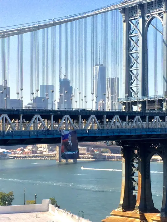 Banner ukuran 6x9 meter bergambar Presiden Rusia Vladimir Putin tergantung di Jembatan Manhattan, New York, Kamis (6/10). Pada banner itu terlihat gambar Putin yang menggunakan jas di depan bendera Rusia. (Kathryn Peters/Handout via Reuters)