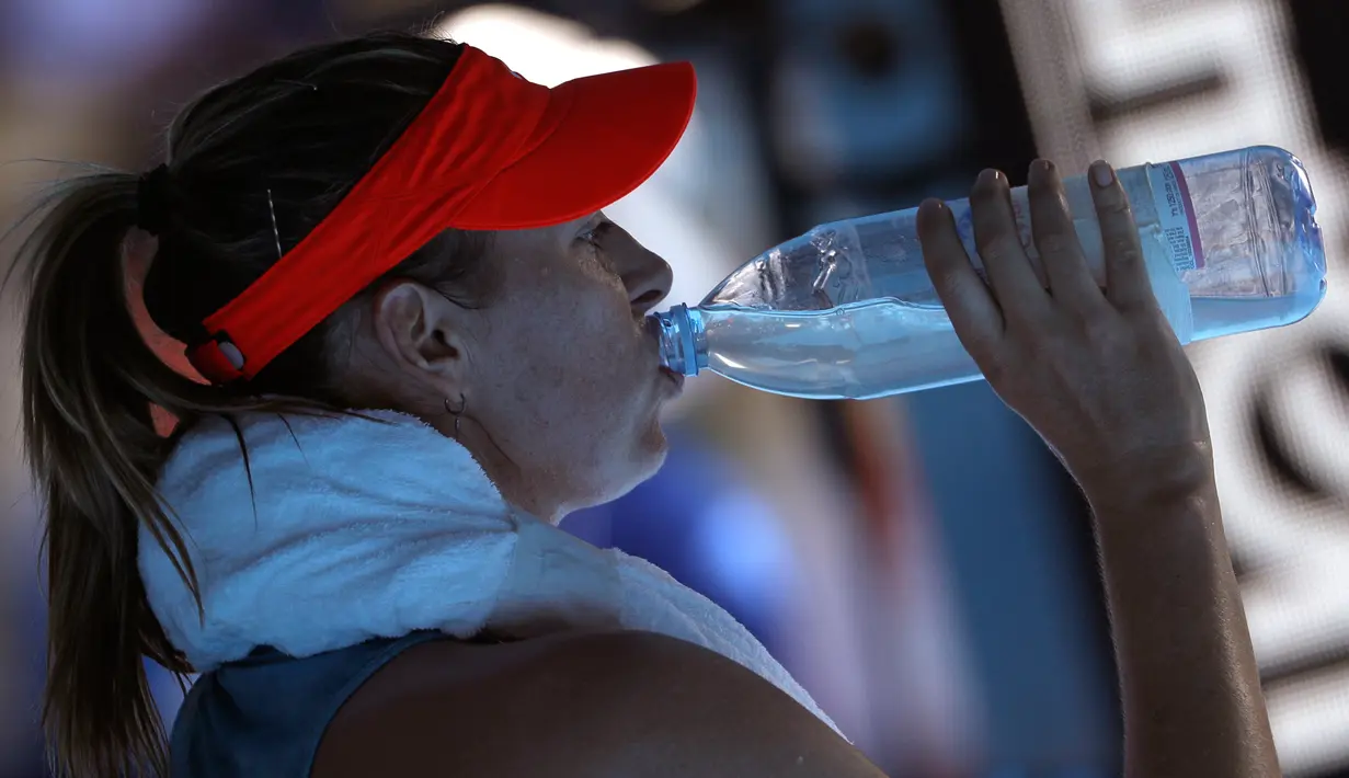 Petenis Rusia Maria Sharapova minum saat pertandingan putaran keempat melawan petenis Australia Ashleigh Barty di kejuaraan tenis Australia Terbuka di Melbourne, Australia(20/1). Sharapova kalah 4-6 6-1 6-4. (AP Photo/Mark Schiefelbein)