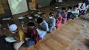 Antrean anak-anak saat menunggu untuk menyetor ayat Alquran saat kegiatan homeschooling berbasis pesantren Paket A di Skoba Madani, Parung, Bogor, Rabu (14/4/2021). Bulan Ramadhan, umat muslim memperbanyak ibadah terutama membaca dan mengkaji kandungan Alquran. (merdeka.com/Arie Basuki)
