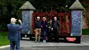 Pengunjung berpose di depan gerbang  Strawberry Fields yang baru dibuka untuk umum di Liverpool, Rabu (18/9/2019). Strawberry Field menjadi salah satu tempat ikonis ketika John Lennon menulis lagu The Beatles “Strawberry Fields Forever” dalam album Sgt.pepper Lonely Hearts Club Band (Paul ELLIS/AFP)