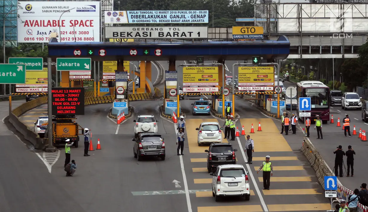 Polisi dan petugas Dishub berjaga di depan Gerbang Tol Bekasi Barat 1, Bekasi, Jawa Barat, Senin (12/3). Peraturan ganjil genap ini berlaku mulai hari ini, Senin (12/3) pukul 06.00-09.00. (Liputan6.com/Arya Manggala)