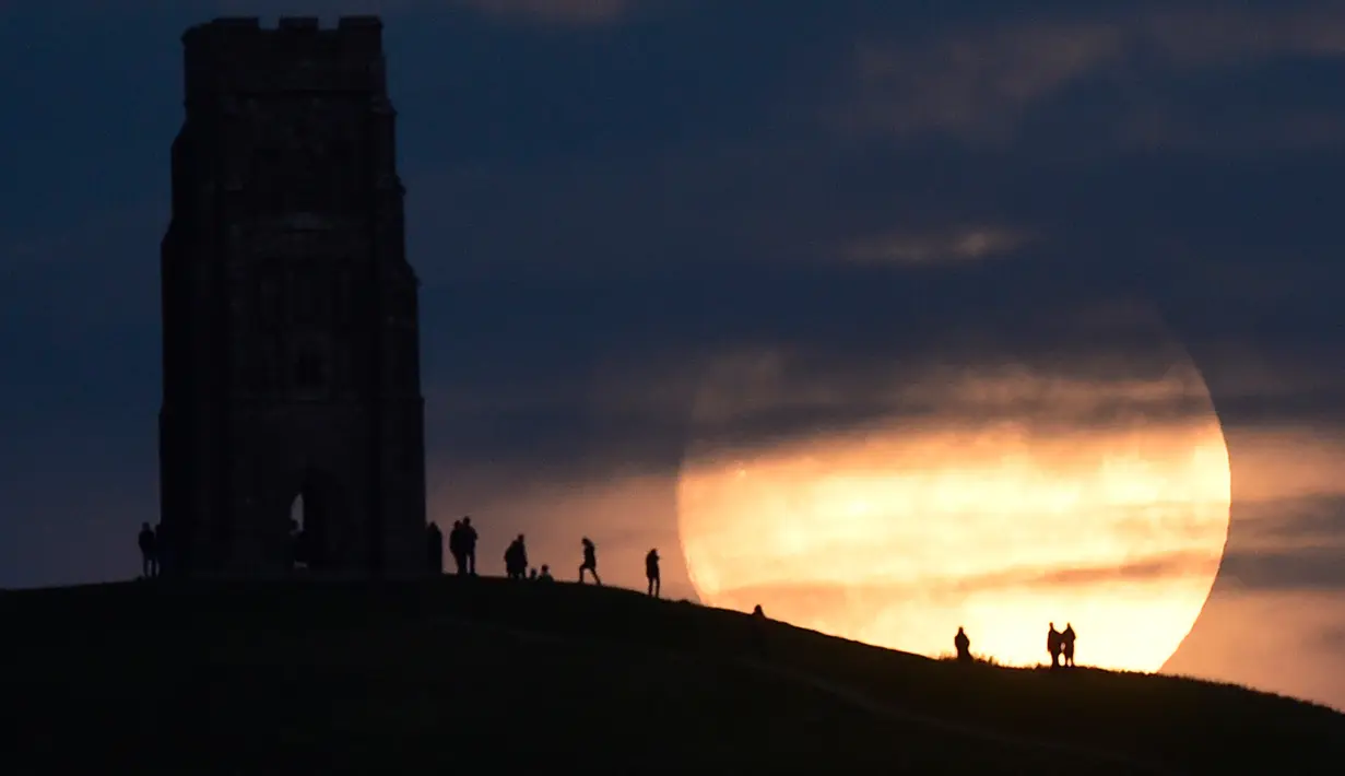 Sejumlah warga menyaksikan fenomena supermoon di Glastonbury, Inggris (13/11). Fenomena ini merupakan bulan paling besar dan terang dalam kurun 70 tahun terakhir. (REUTERS/Rebecca Naden)