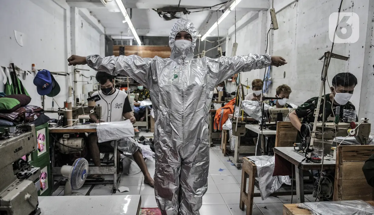 Pekerja mencoba baju hazmat setelah selesai dibuat di salah satu industri konveksi Pusat Industri Kecil (PIK), Jakarta, Rabu (30/12/2020). Budi (48), seorang marketing di Toko Konveksi Baju, mengungkapkan permintaan baju hazmat hingga kini masih tinggi. (merdeka.com/Iqbal S. Nugroho)