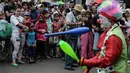 Sejumlah warga menyaksikan aksi badut yang tergabung dalam Aku Badut Indonesia menghibur masyarakat saat car free day di Bunderan HI, Jakarta, Minggu (9/12). (Liputan6.com/Faizal Fanani)