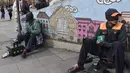 Dua tukang semir sepatu menunggu pelanggan di kawasan La Paz, Bolivia (29/11). Banyak diantara mereka masih menjalani pendidikan di sekolah dan universitas. (AFP PHOTO/Aizar Raldes)