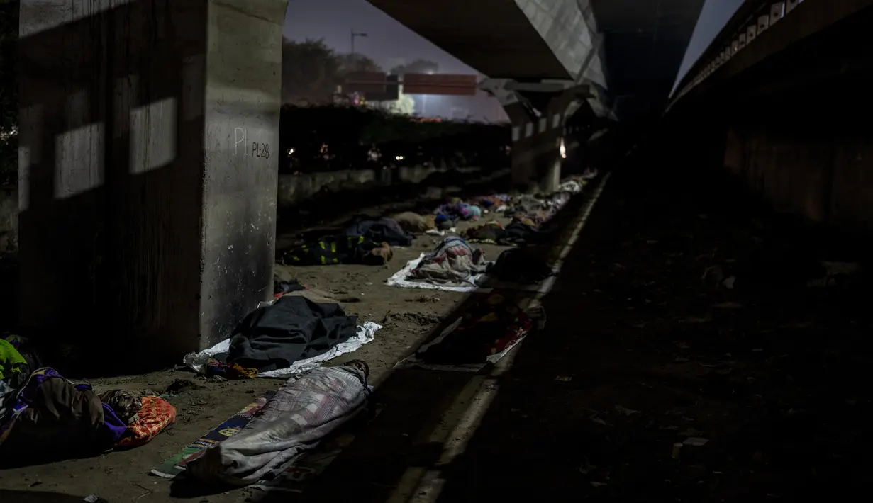 Tunawisma tidur di tempat terbuka di bawah jembatan penyeberangan pada malam yang dingin di New Delhi, Rabu, 28 Desember 2022. Angka sensus India tahun 2011 menunjukkan sekitar 47.000 penduduk kota itu tidur tanpa rumah, tetapi para aktivis mengatakan jumlahnya terlalu rendah dan bahwa New Delhi memiliki lebih dari 150.000 orang yang sulit tidur. (AP Photo/Altaf Qadri)