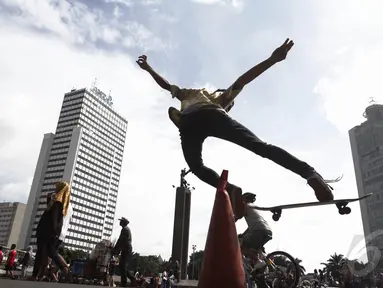 Seorang remaja beraksi dengan skateboard-nya saat hari bebas kendaraan (car free day) di kawasan Bundaran HI Jakarta, Minggu (14/12/2015). (Liputan6.com/Faizal Fanani)
