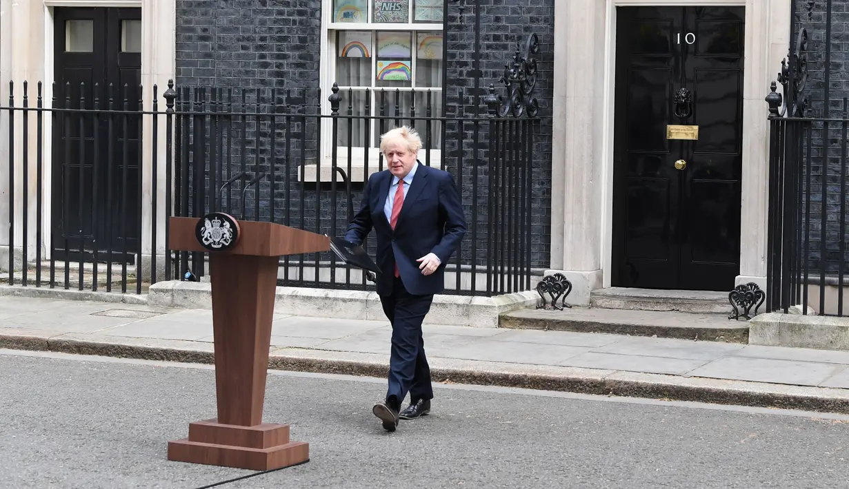 Perdana Menteri Inggris, Boris Johnson berjalan keluar dari 10 Downing Street untuk memberikan pernyataan pada hari pertamanya kembali bekerja di London, Senin (27/4/2020). Ini menjadi kemunculan pertama PM Johnson di depan publik setelah hampir sebulan terinfeksi COVID-19.  (DANIEL LEAL-OLIVAS/AFP)