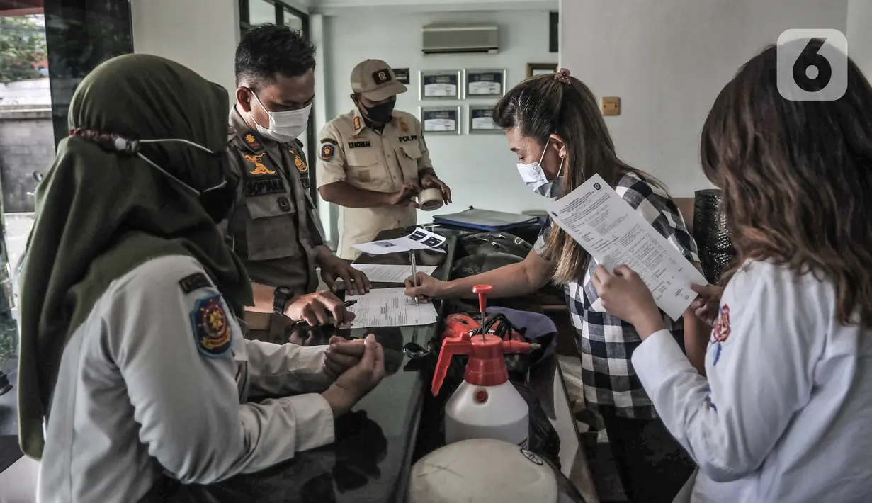 Pegusaha menandatangani surat teguran tertulis yang diberikan petugas Satpol PP saat sidak di salah satu perkantoran kawasan Sunter, Jakarta, Rabu (10/2/2021). Sidak tersebut merupakan bagian dari penerapan Pemberlakuan Pembatasan Kegiatan Masyarakat (PPKM) skala mikro. (merdeka.com/Iqbal s Nugroho)