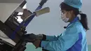 Pekerja memakai masker di Pabrik Sepatu Kulit Wonsan, tempat mereka memproduksi sepatu kulit buatan tangan di Wonsan, Provinsi Kangwon, Korea Utara pada 28 Oktober 2020. (AP Photo/Jon Chol Jin)