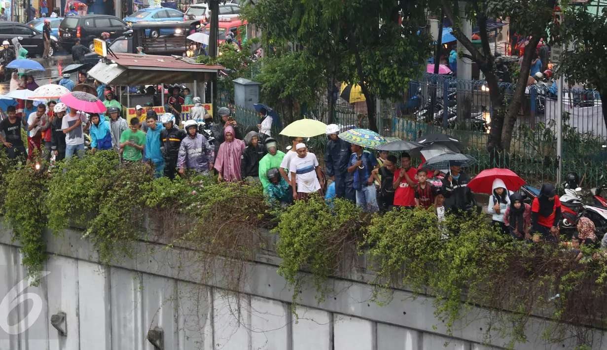 Warga menonton JPO yang roboh akibat hujan deras dan angin kencang di Jalan Raya Pasar Minggu, Jakarta Selatan, Sabtu (24/09). Kejadian itu menyebabkan arus lalin dari arah Pancoran dan sebaliknya mengalami kemacetan. (Liputan6.com/Immanuel Antonius)