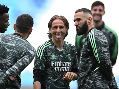 Pemain Real Madrid, Luka Modric (kedua kiri) bercanda dengan rekannya saat melakukan latihan menjelang laga semifinal Liga Champions 2022/2023 melawan Manchester City di Etihad Stadium, Manchester, Selasa (16/05/2023) waktu setempat. (AFP/Oli Scarff)